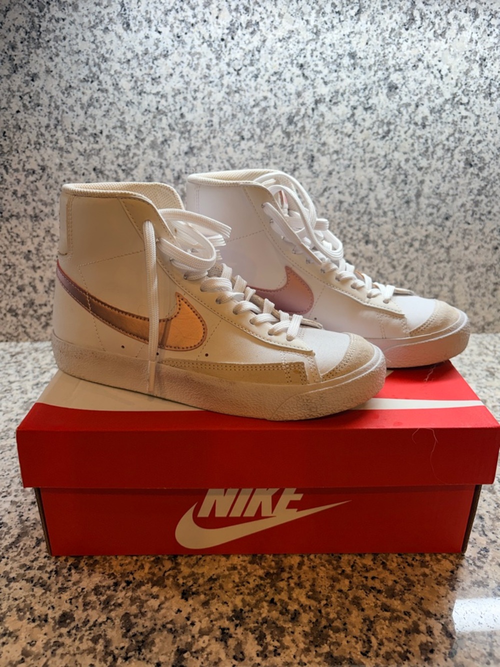 Nike Women's High-Top Sneakers in White with Rose Gold Swoosh.